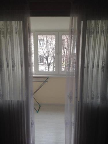 una ventana abierta con cortinas en una habitación en VIP apart 322, en Okrokana
