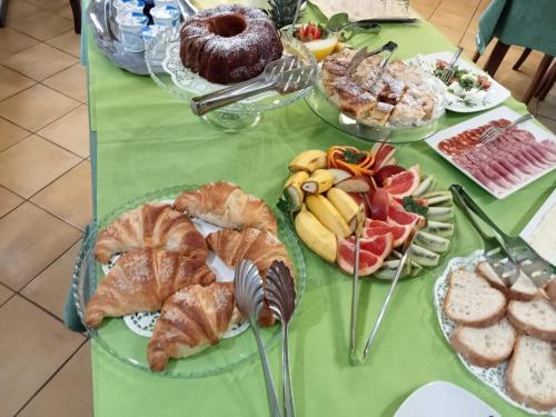 einen Tisch mit Platten aus Gebäck und anderen Lebensmitteln in der Unterkunft HOTEL POSIDONIA INN SAPRI in Sapri