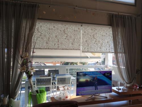 a television sitting on a desk in front of a window at Lia Luxury home 2ΥΔ 110 τ μ in Chrysoupolis