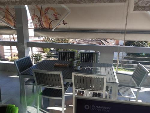 a dining table and chairs on a balcony with a table and chairs at Lia Luxury home 2ΥΔ 110 τ μ in Chrysoupolis
