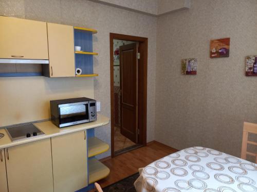 a small kitchen with a microwave on a counter at Daugavpils City Centеr Apartment in Daugavpils
