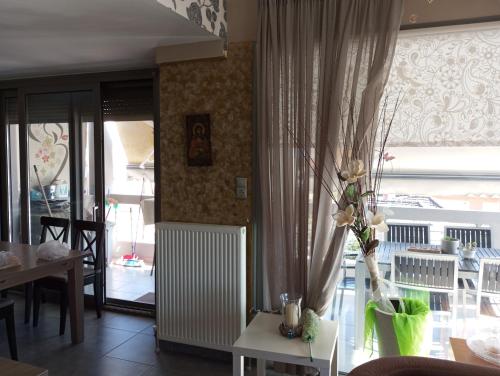 a living room with a vase of flowers on a table at Lia Luxury home 2ΥΔ 110 τ μ in Chrysoupolis