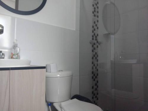 a bathroom with a toilet and a sink and a shower at Acogedor apartamento con sala de TV in Sabaneta