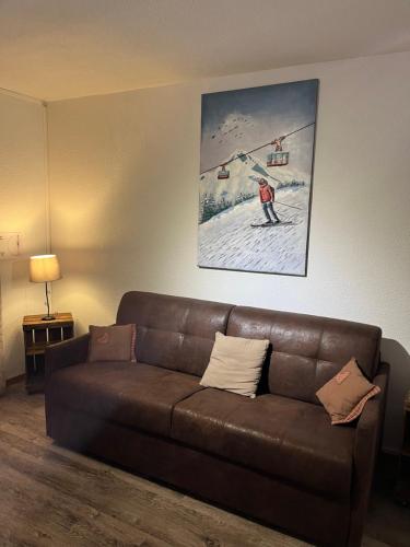 a brown couch in a living room with a ski lift at Chalet L'Hermine in Val Thorens