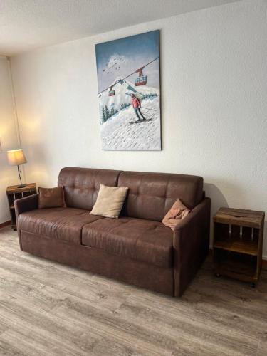 a brown couch in a living room with a picture on the wall at Chalet L'Hermine in Val Thorens