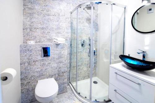 a bathroom with a shower and a toilet and a sink at Apartament "Biała Perła" in Dziwnówek