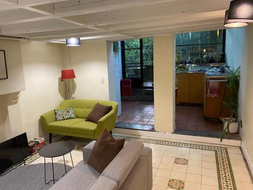 - un salon avec un canapé et un fauteuil vert dans l'établissement B&B Faja lobi, à Gand