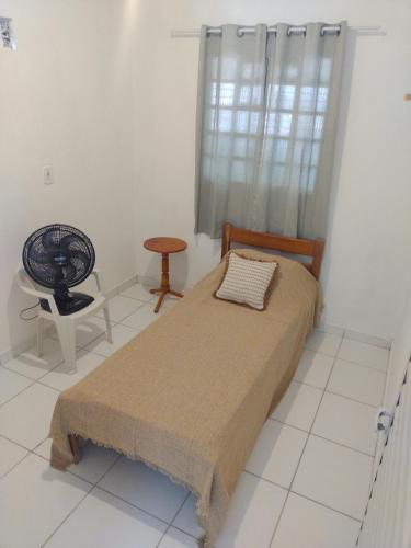 ein Schlafzimmer mit einem Bett, einem Stuhl und einem Fenster in der Unterkunft Casa Naturaleza in Barra do Garças
