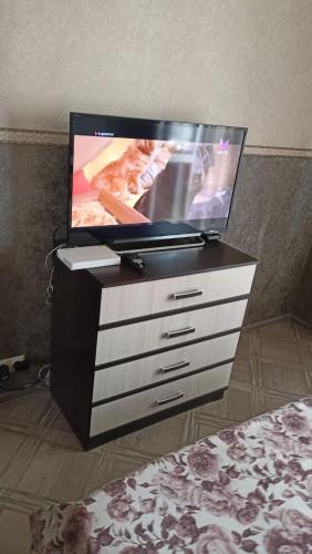 uma televisão de ecrã plano sentada numa cómoda em VIP apart 323 em Tbilisi