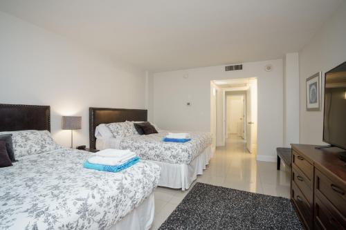 a bedroom with two beds and a flat screen tv at Ocean Reserve 14th floor - Wonderful Ocean View - STR00454 in Miami Beach