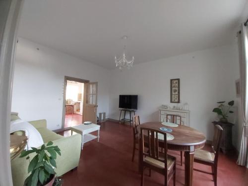- un salon avec une table, des chaises et une télévision dans l'établissement Villa Victoire - Maison - couple 2 personnes, à Rochefort