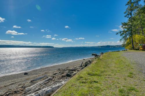 a sandy beach next to a body of water at Harstine Island Cabin with Fire Pit Walk to Beach! in Lakebay