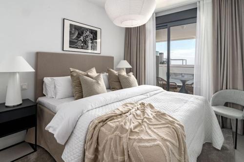 エステポナにあるLME133A- Stunning flat close to beach in Esteponaの大きな白いベッドとバルコニーのある寝室