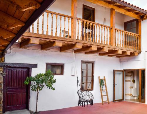 a building with a wooden staircase and a bench at Casa ENTREPIEDRAS in Villalís