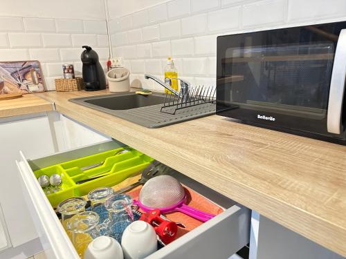 a kitchen counter with a sink and a microwave at Au cœur de la plaine 2 in Capesterre-Belle-Eau