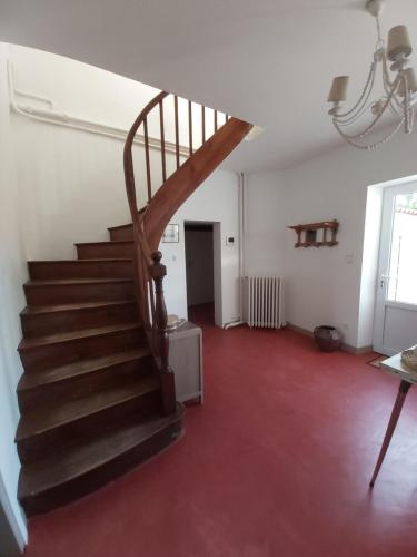 - un escalier en bois dans une chambre dotée d'une moquette rouge dans l'établissement Villa Victoire - Maison - couple 2 personnes, à Rochefort