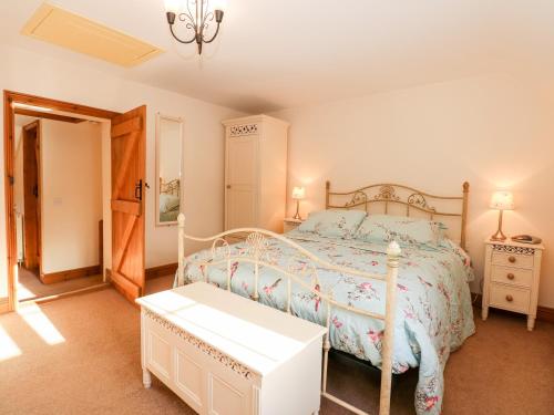 a bedroom with a bed and a table in it at Kath's Cottage in Heacham