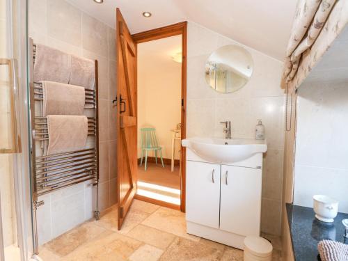 a bathroom with a sink and a mirror at Kath's Cottage in Heacham