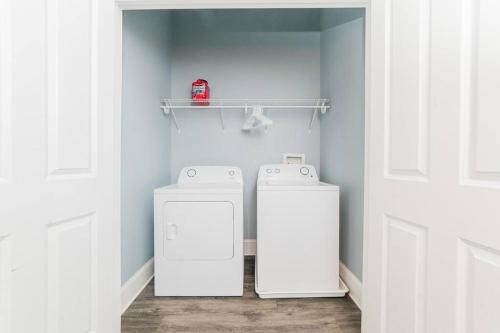 a laundry room with two refrigerators and a shelf at Walkable and Spacious Apt - Parking -- GroupStay in Pittsburgh