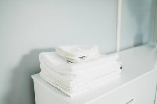 una pila de toallas blancas en un estante del baño en Walkable and Spacious Apt - Parking -- GroupStay en Pittsburgh