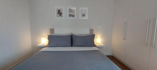 a small bedroom with a bed with two lights on it at Highrise Madalenas Apartment in Funchal