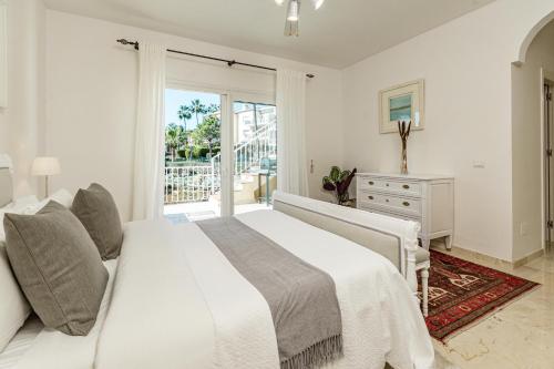 um quarto branco com uma cama grande e uma janela em LBP2- Family apartment in calm area families only em Marbella