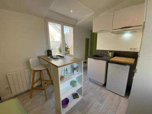 - une petite cuisine avec un comptoir et une table dans l'établissement Studio en Rez de jardin Le clos des Cent Vignes à Beaune, à Beaune