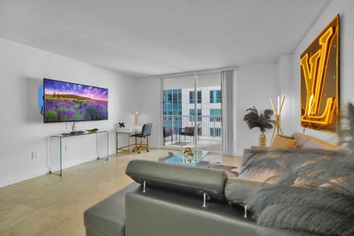 a living room with a couch and a flat screen tv at Zeus' Sanctuary Ocean View In Brickell Miami in Miami