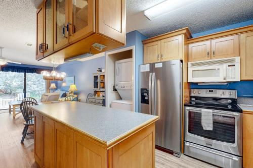 a kitchen with stainless steel appliances and wooden cabinets at Buddy's Place at the Beach in New Smyrna Beach