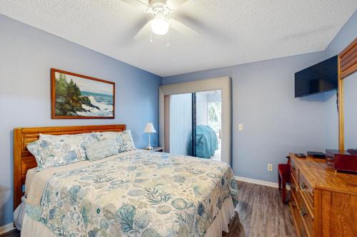 a bedroom with a bed and a dresser with a television at Buddy's Place at the Beach in New Smyrna Beach