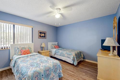 a bedroom with two beds and a ceiling fan at Buddy's Place at the Beach in New Smyrna Beach