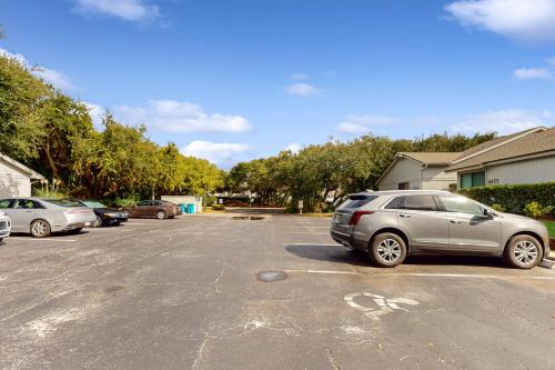 a parking lot with several cars parked in it at Buddy's Place at the Beach in New Smyrna Beach
