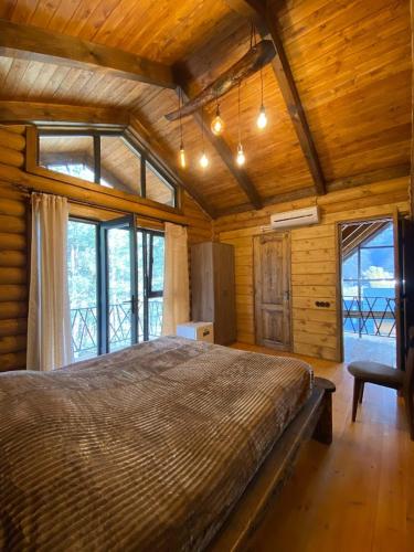 a bedroom with a large bed in a room with windows at Arte Jermuk Lux Cottage in Jermuk