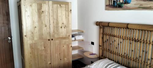 um quarto com um armário de madeira ao lado de uma cama em Apartamento Porto Antigo 2 em Santa Maria