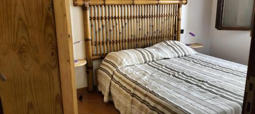 um quarto com uma cama e uma cabeceira em madeira em Apartamento Porto Antigo 2 em Santa Maria
