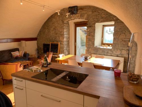 een keuken en een woonkamer met een stenen muur bij La Vigneronne, Chailly-Montreux in Montreux