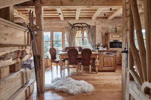 a dining room with a table and chairs in a cabin at GORSKA OSADA Lovely Chalets Zakopane in Poronin