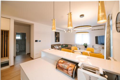 een woonkamer en eetkamer met gele stoelen bij Nika apartman in Surčin