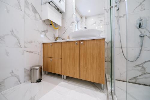 ein Bad mit einem Waschbecken und einer Dusche in der Unterkunft Nika apartman in Surčin