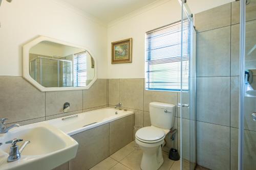 ein Bad mit einem WC, einem Waschbecken und einer Dusche in der Unterkunft Midlands Cottage with Views in Henburg Park