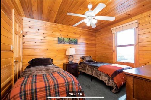 a bedroom with two beds and a ceiling fan at Private Lakefront Sanctuary in Matlock
