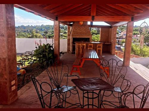 um pátio com cadeiras, uma mesa e uma lareira em Chalet " La Maruca " em Villa Carlos Paz