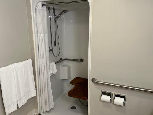 a bathroom with a shower with white towels at Days Inn by Wyndham St Augustine I-95-Outlet Mall in Saint Augustine