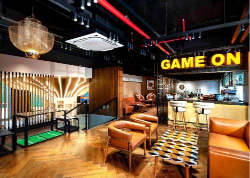 a game room with leather chairs and a bar at Ginger Mumbai Airport in Mumbai