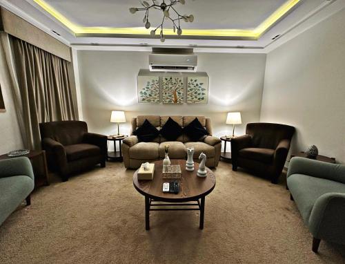 ein Wohnzimmer mit einem Sofa, einem Tisch und Stühlen in der Unterkunft The Arabella House - Madinaty in Madinaty