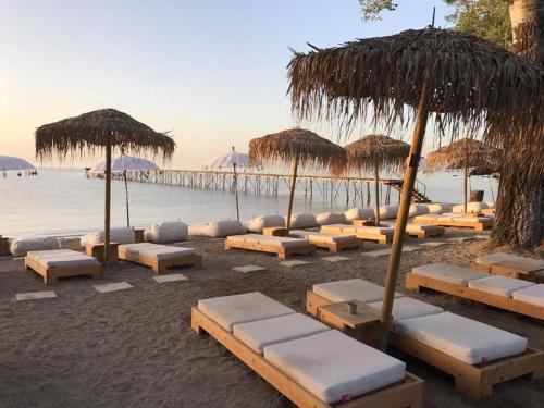 a beach with lounge chairs and umbrellas and the ocean at Blue View House in Corfu Town