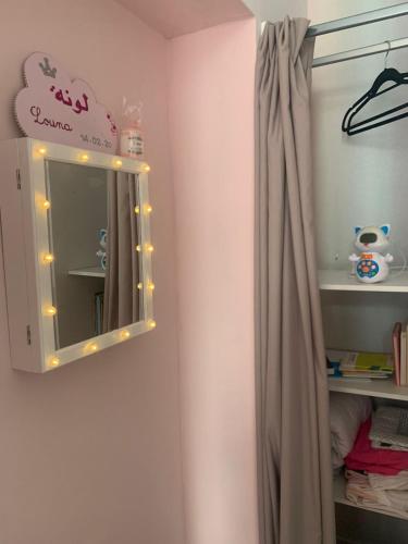 - un miroir avec des lumières sur un mur dans l'établissement Charmante petite maison, à Maubeuge