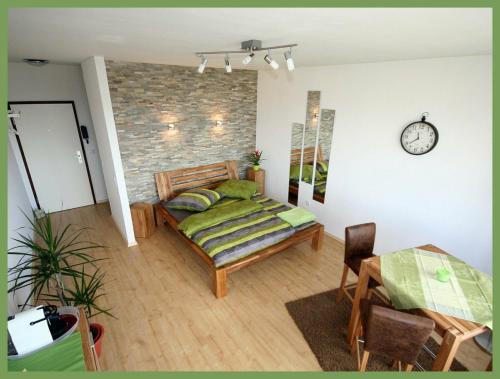 a bedroom with a bed and a table and a clock at Apartment SONNE - ruhig in der Nähe des Hauptbahnhof in Braunschweig