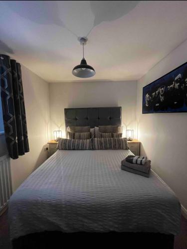 a bedroom with a large bed with a white bedspread at Contemporary Seaside Apartment in Bangor
