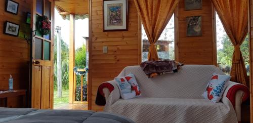 ein Wohnzimmer mit einem Sofa und einem Fenster in der Unterkunft Cabaña Los Linos in Guasca
